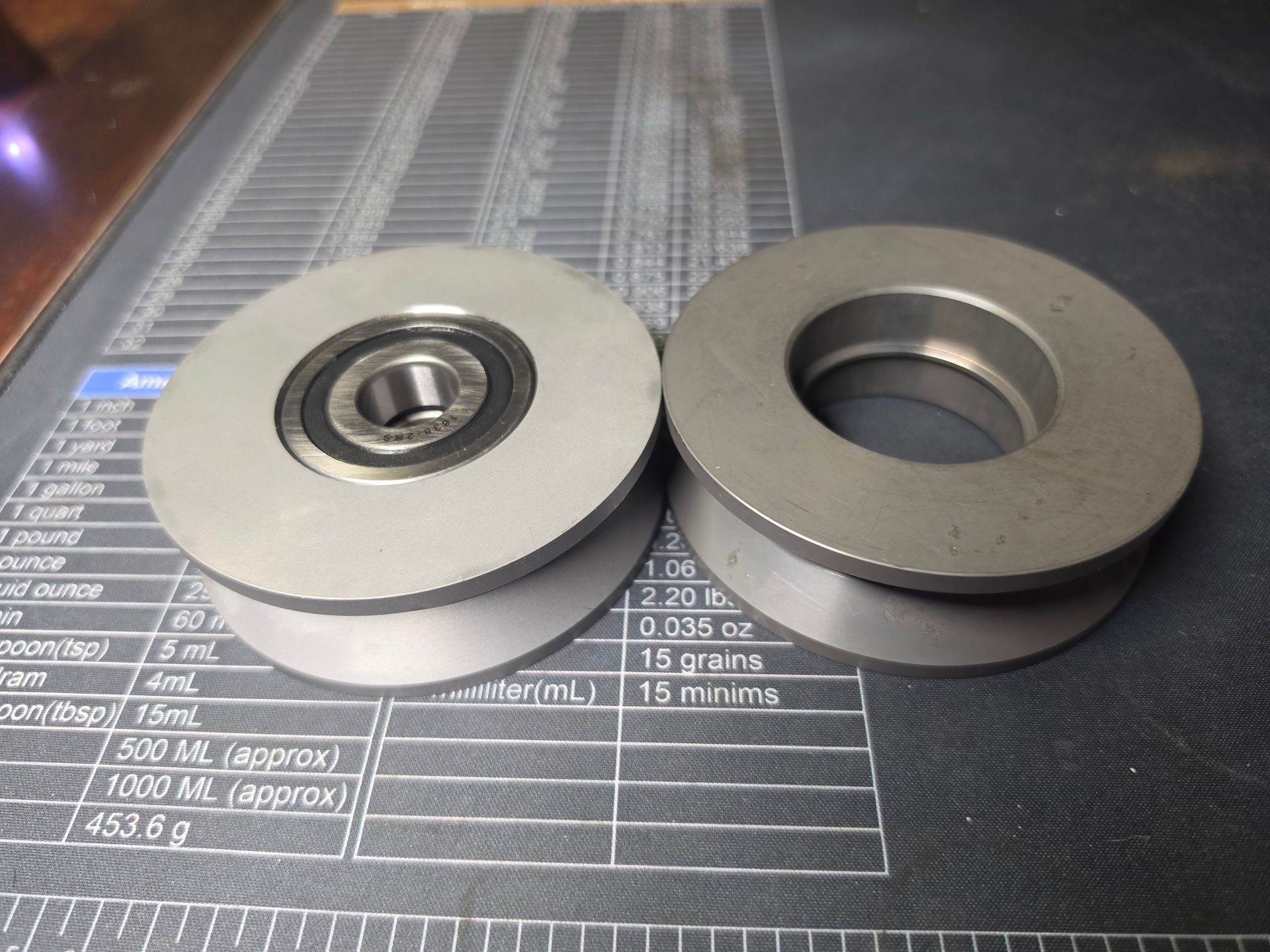 Two metal washers, one with a ball bearing, on a measuring mat