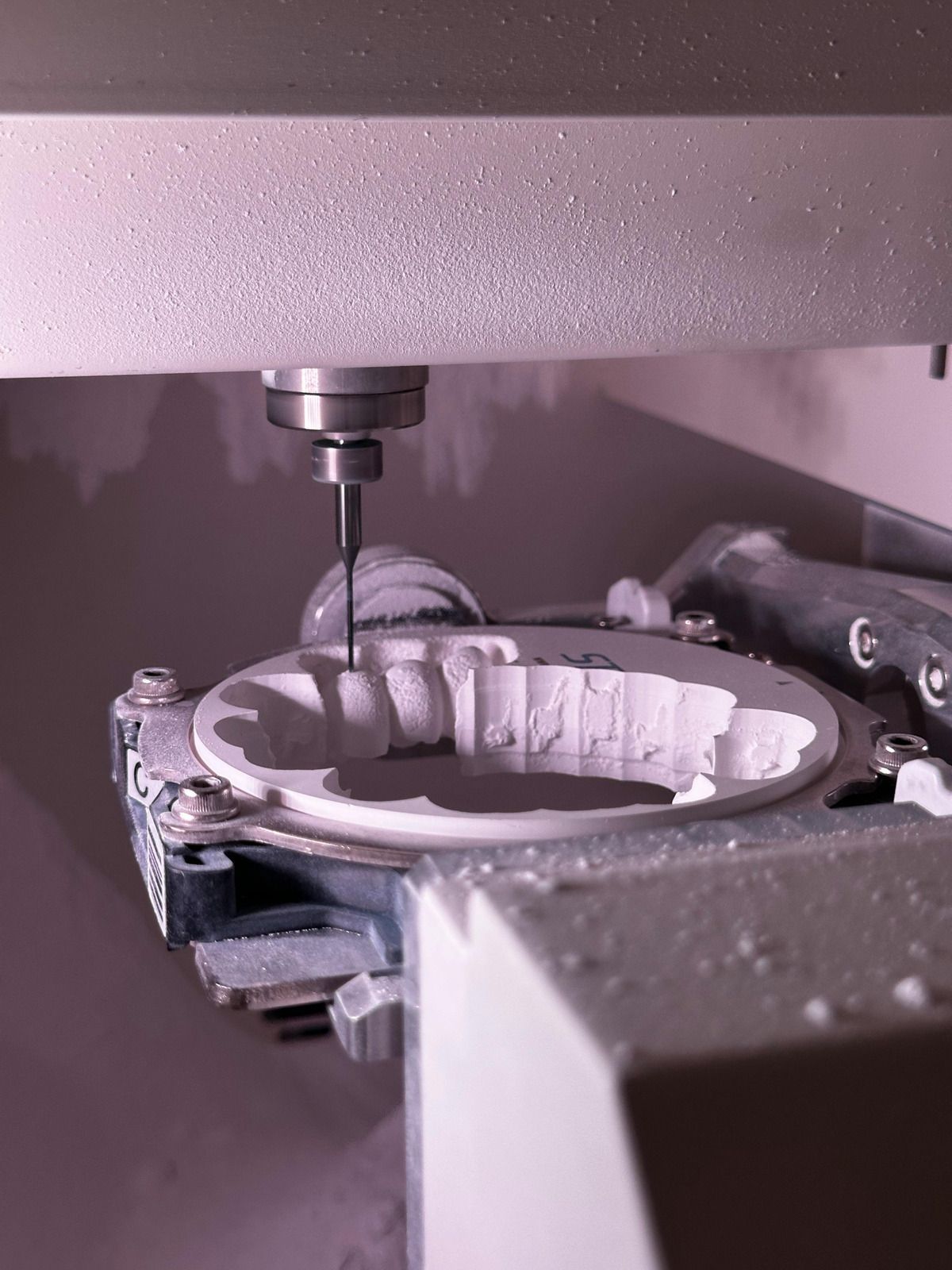 CNC machine milling a metal gear.