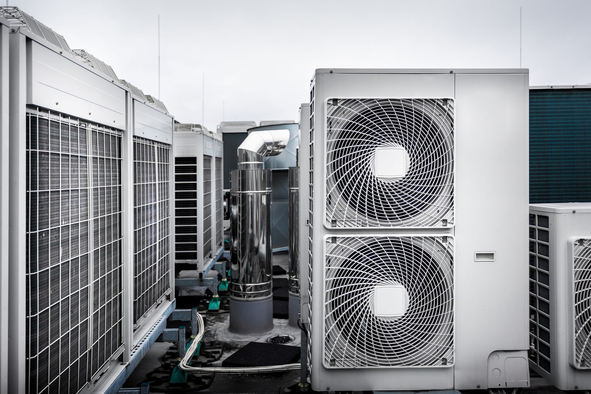 Outdoor HVAC units with large fans and metal grilles on a rooftop. Outdoor HVAC units with large fans and metal grilles on a rooftop.