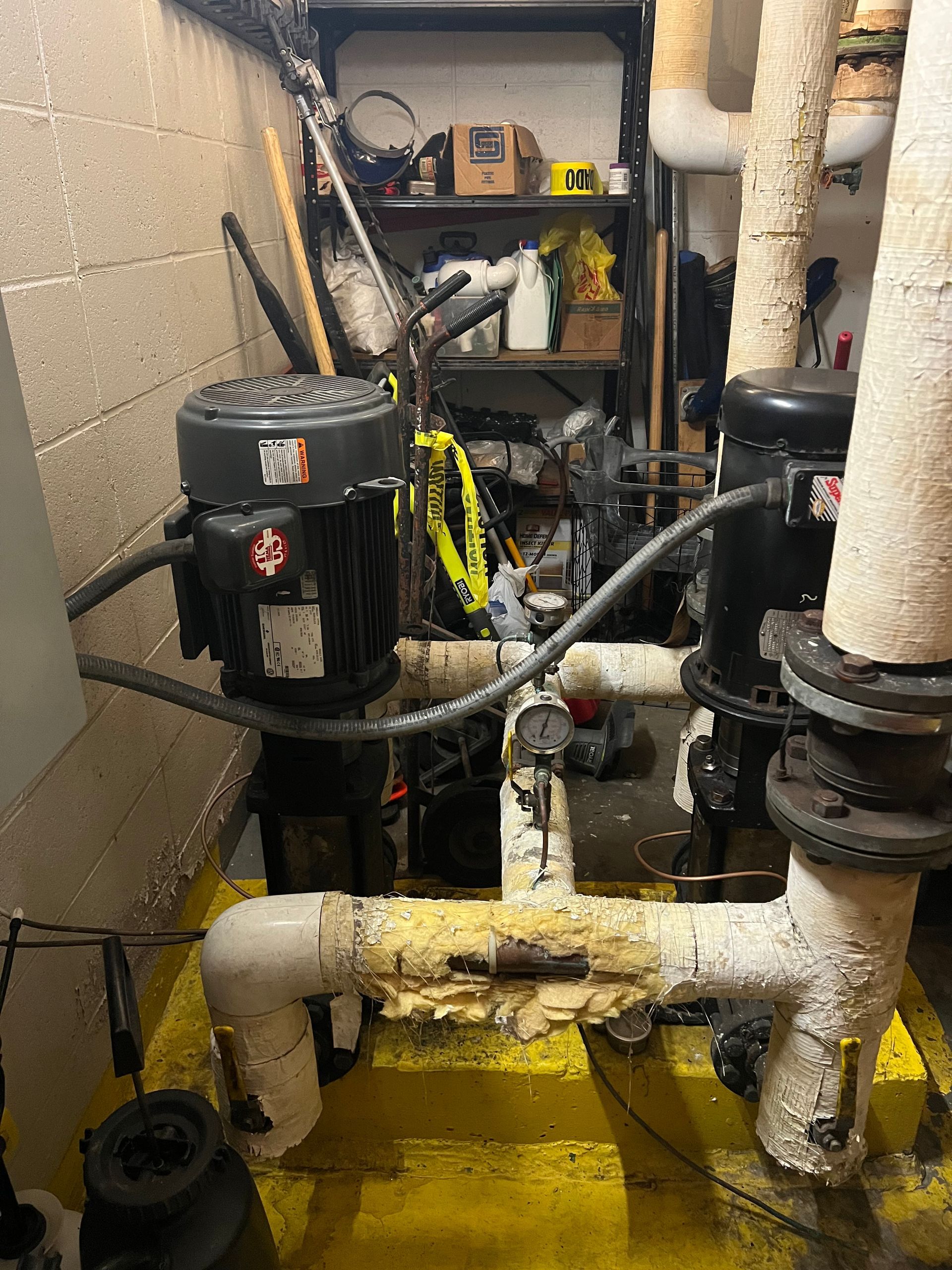 Plumber adjusting copper pipes and valves inside a utility room with tools in hand Plumber adjusting copper pipes and valves inside a utility room with tools in hand