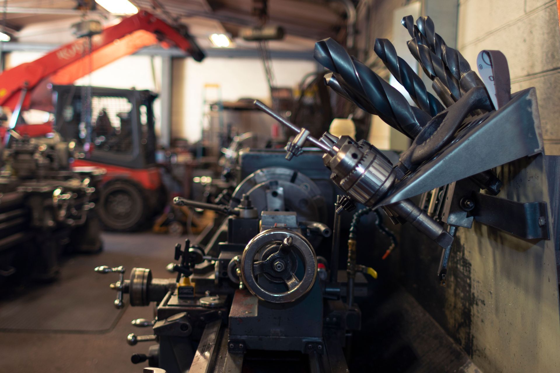 Machinery parts on an assembly line in a dim industrial workshop, with metal components in the foreground.