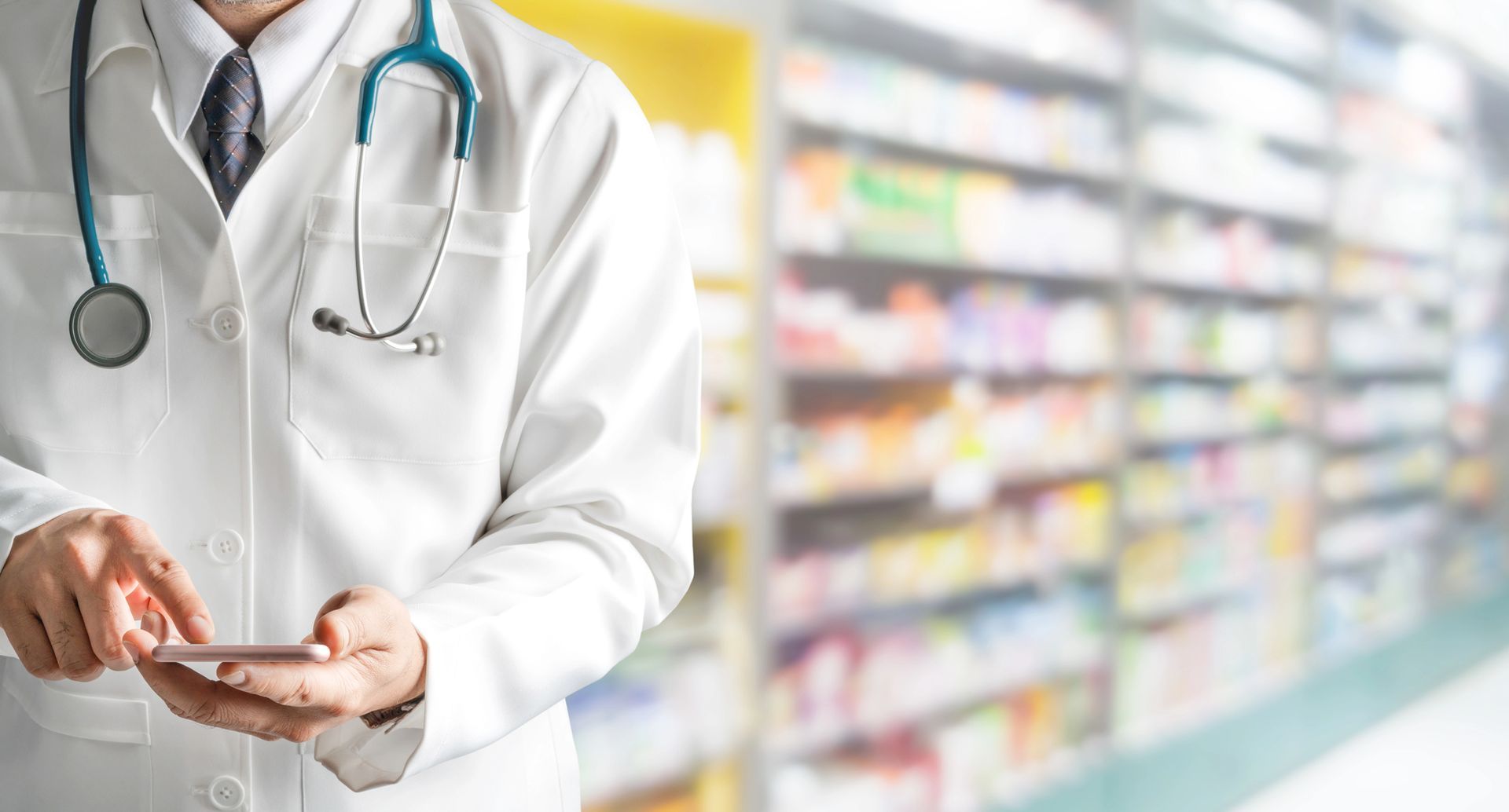 Un médico está usando un teléfono celular en una farmacia.