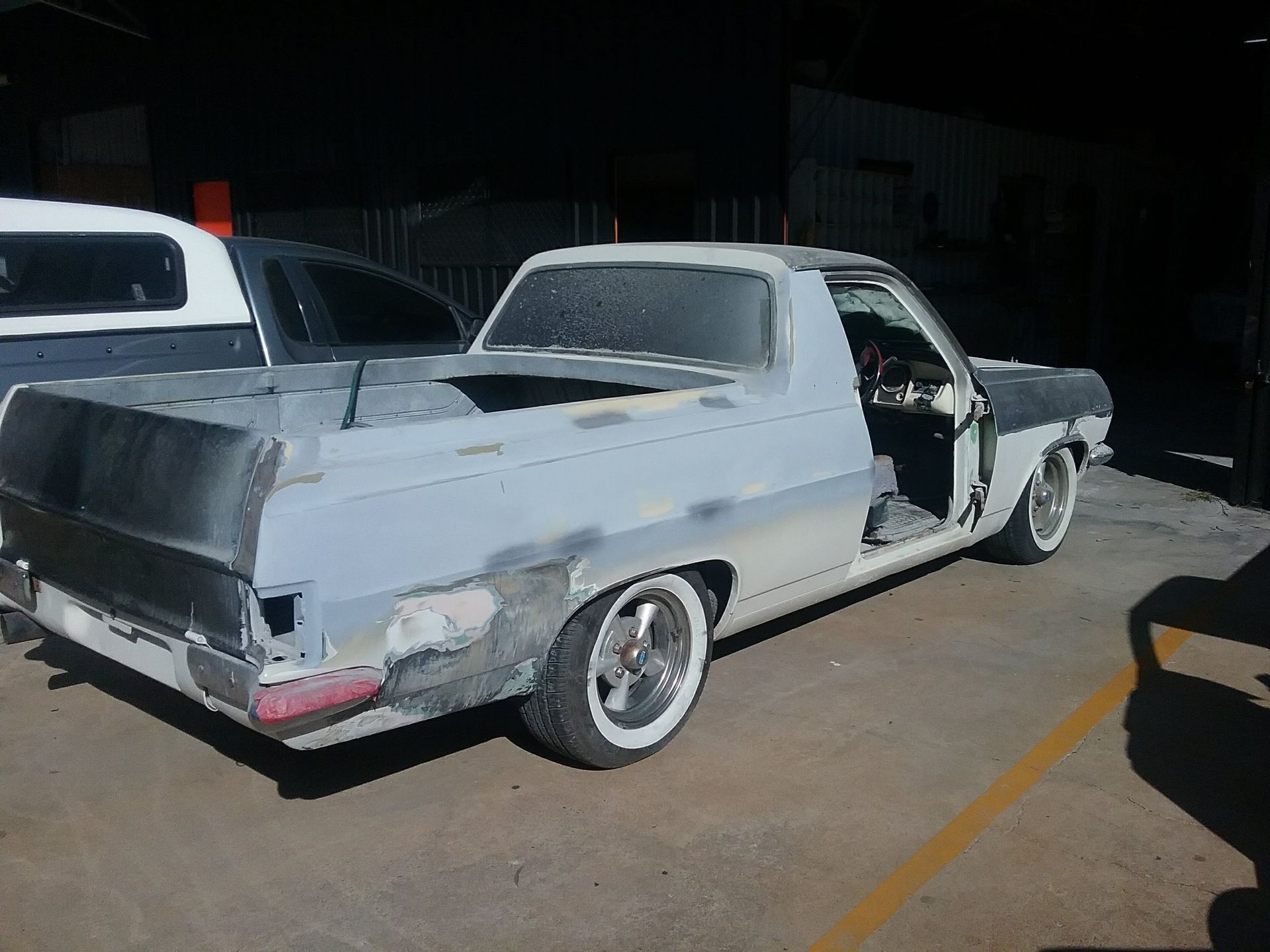 A large piece of car metal is elevated in a garage — Proserpine Smash Repairs & Restorations In Proserpine, QLD