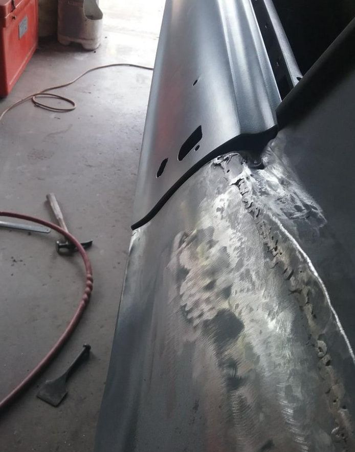 A rusty piece of metal is being worked on in a garage — Proserpine Smash Repairs & Restorations In Proserpine, QLD