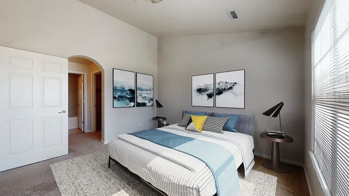 Bedroom with a king-size bed, arched doorway to bathroom, and abstract art on walls.
