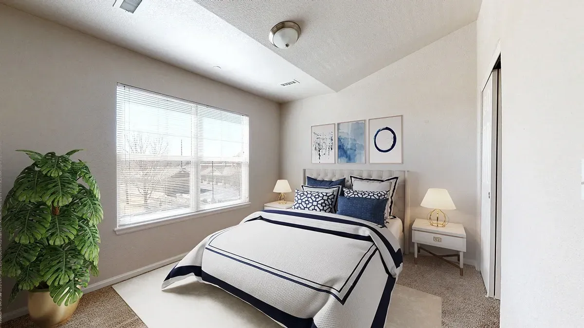Cozy bedroom with a queen-size bed, bedside tables, and a large window with blinds.
