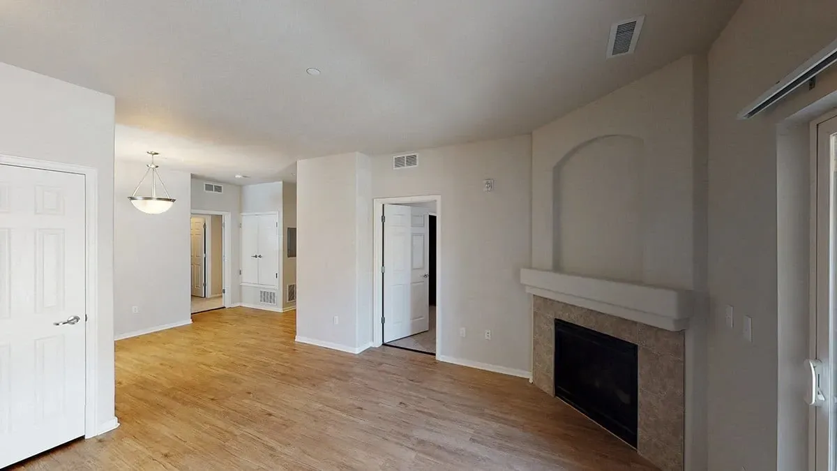 Living room with fireplace and wood flooring.