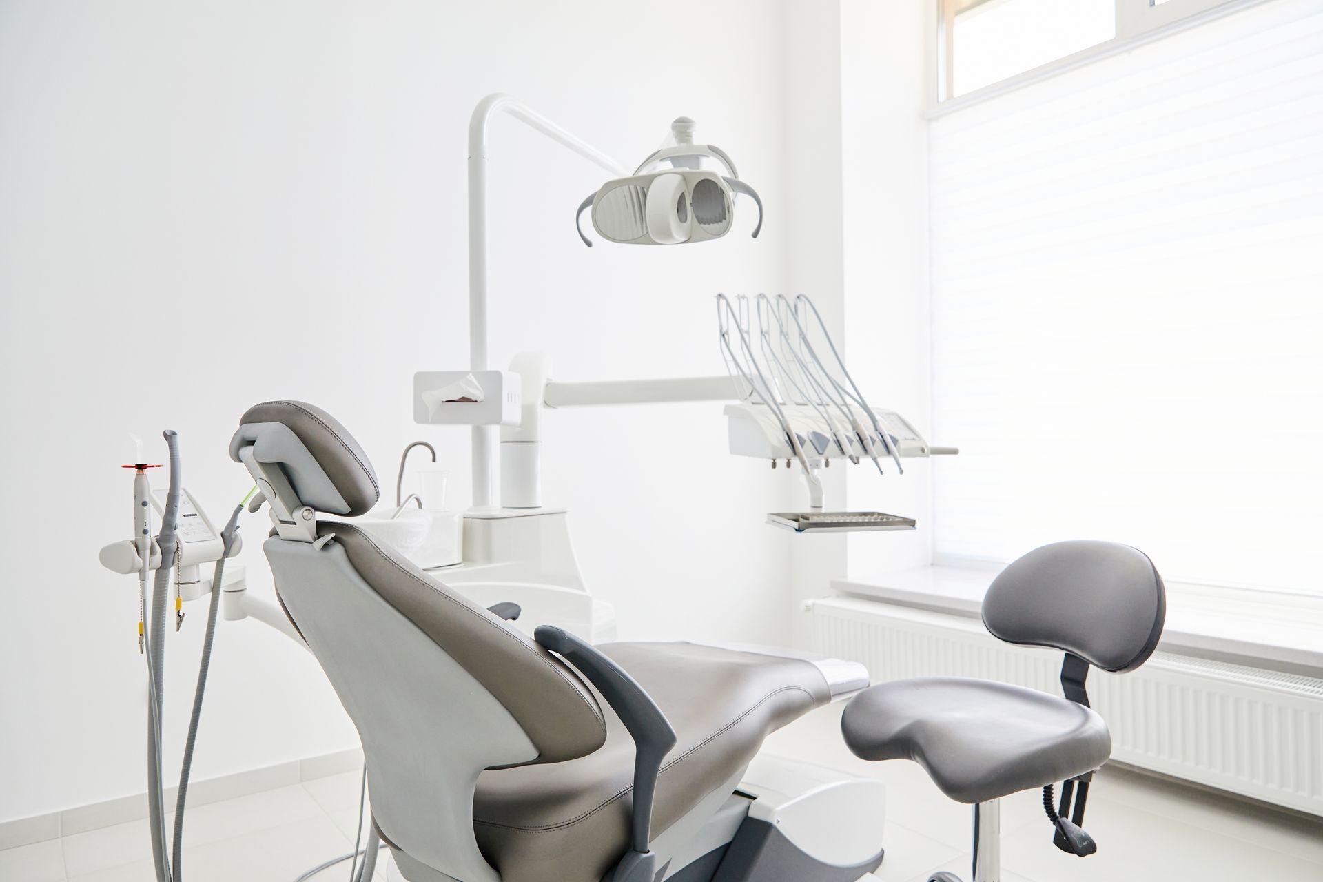 An empty dental office with a dental chair and dental equipment.