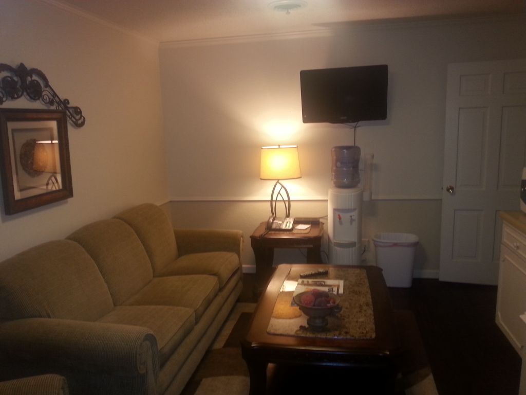 Cozy living room with beige sofa, coffee table, lamp, TV, and front door.