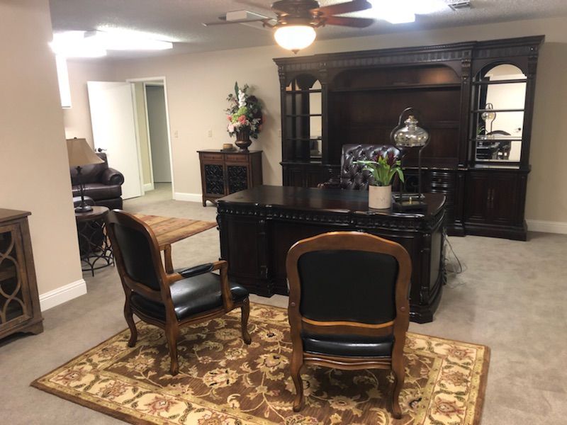 Formal dining room with dark wood furniture, patterned rug, and overhead ceiling fan.