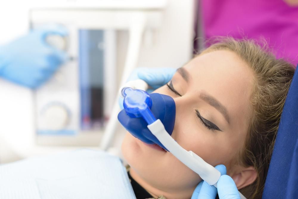Woman Is Laying In A Dental Chair With An Oxygen Mask On Her Face — Byron Bay Dental in Byron Bay, NSW
