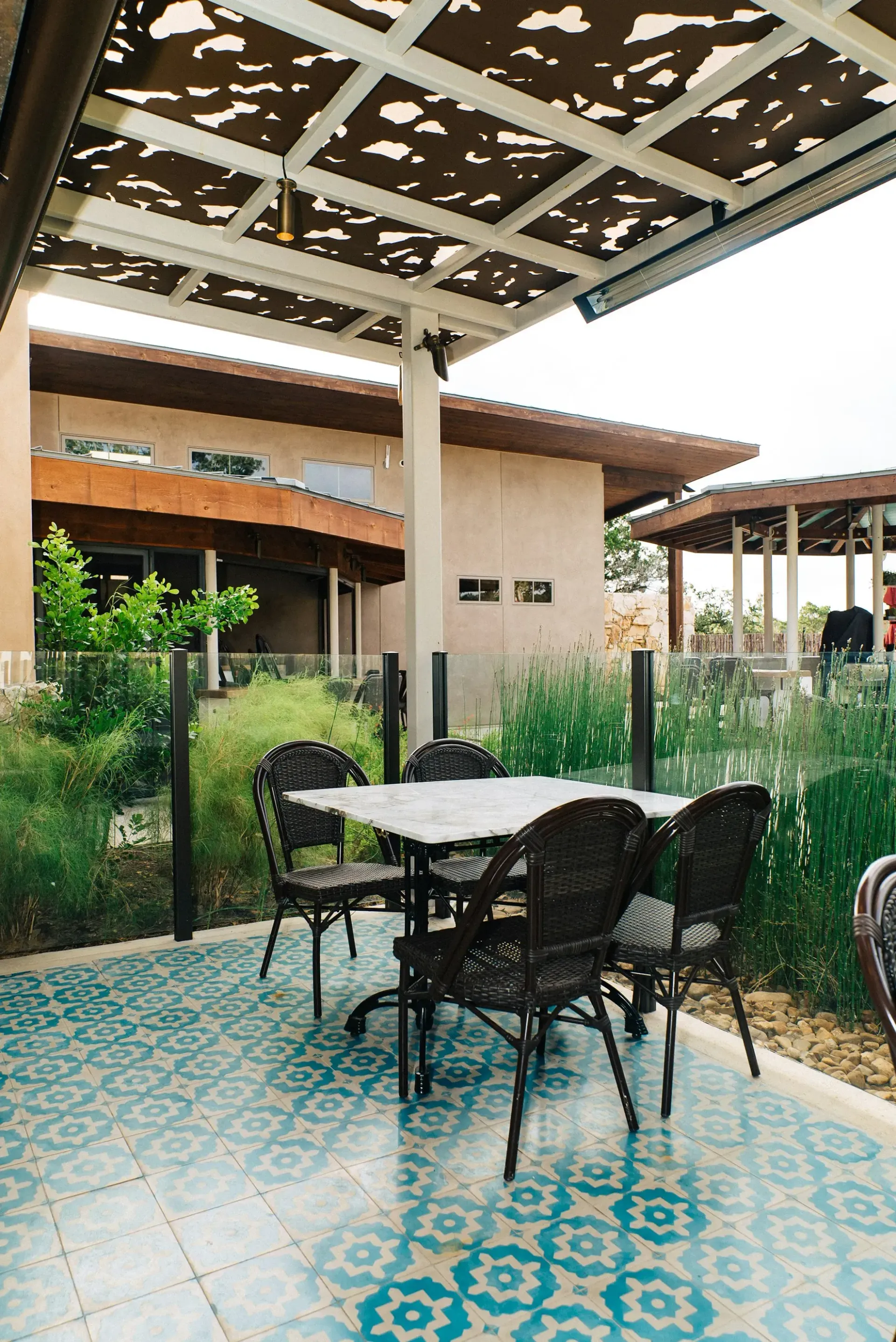 A patio with a table and chairs under a pergola.