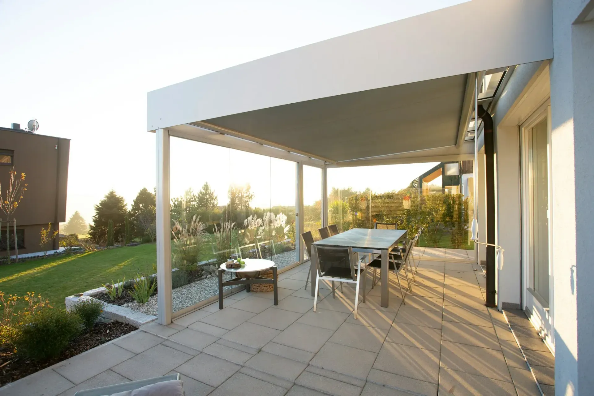 A patio with a table and chairs under a pergola.
