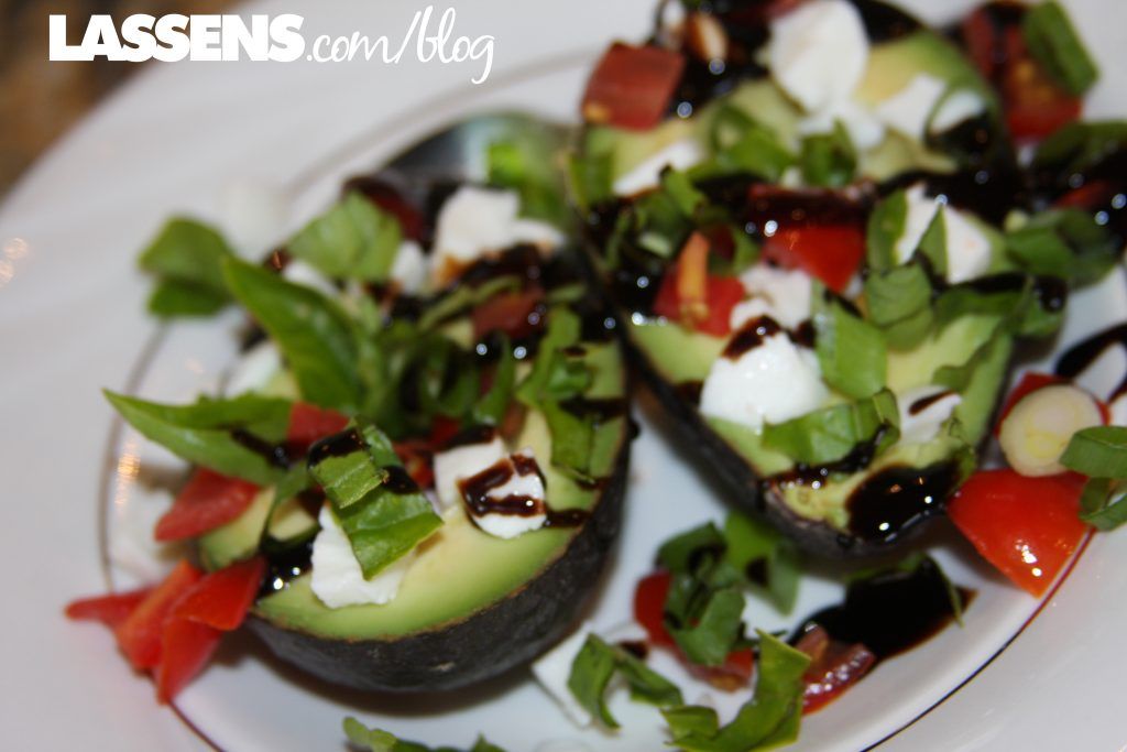 Avocado halves filled with mozzarella, tomatoes, basil, and balsamic glaze.