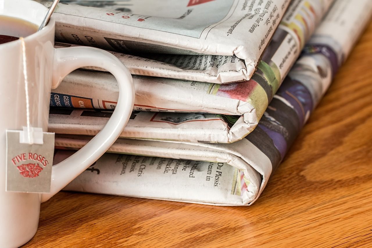 A Media Company Exec is Looking a a Stack of Newspapers But Thinking About Winning More Digital Advertising Dollars