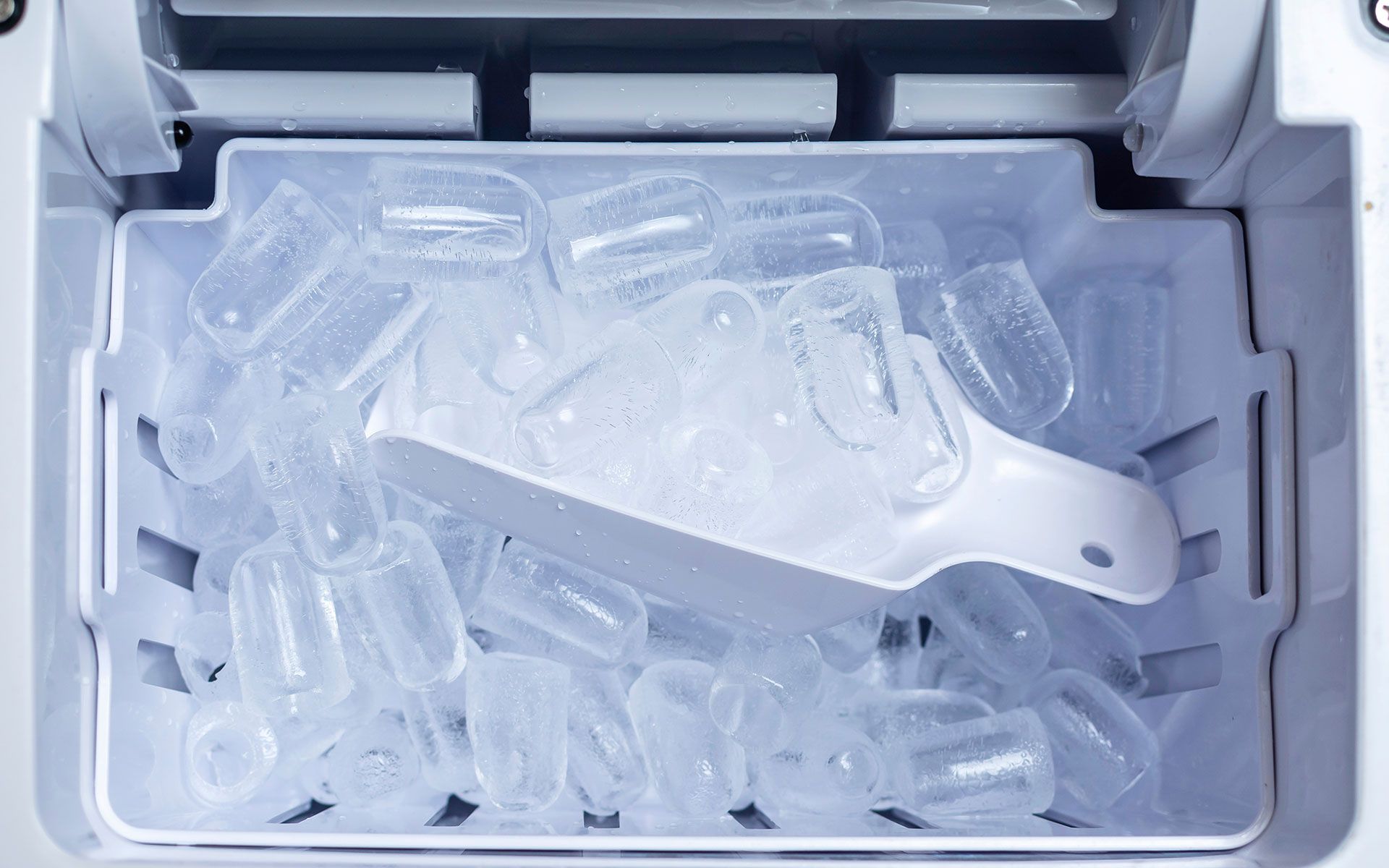 A bucket of ice cubes with a scoop in it.