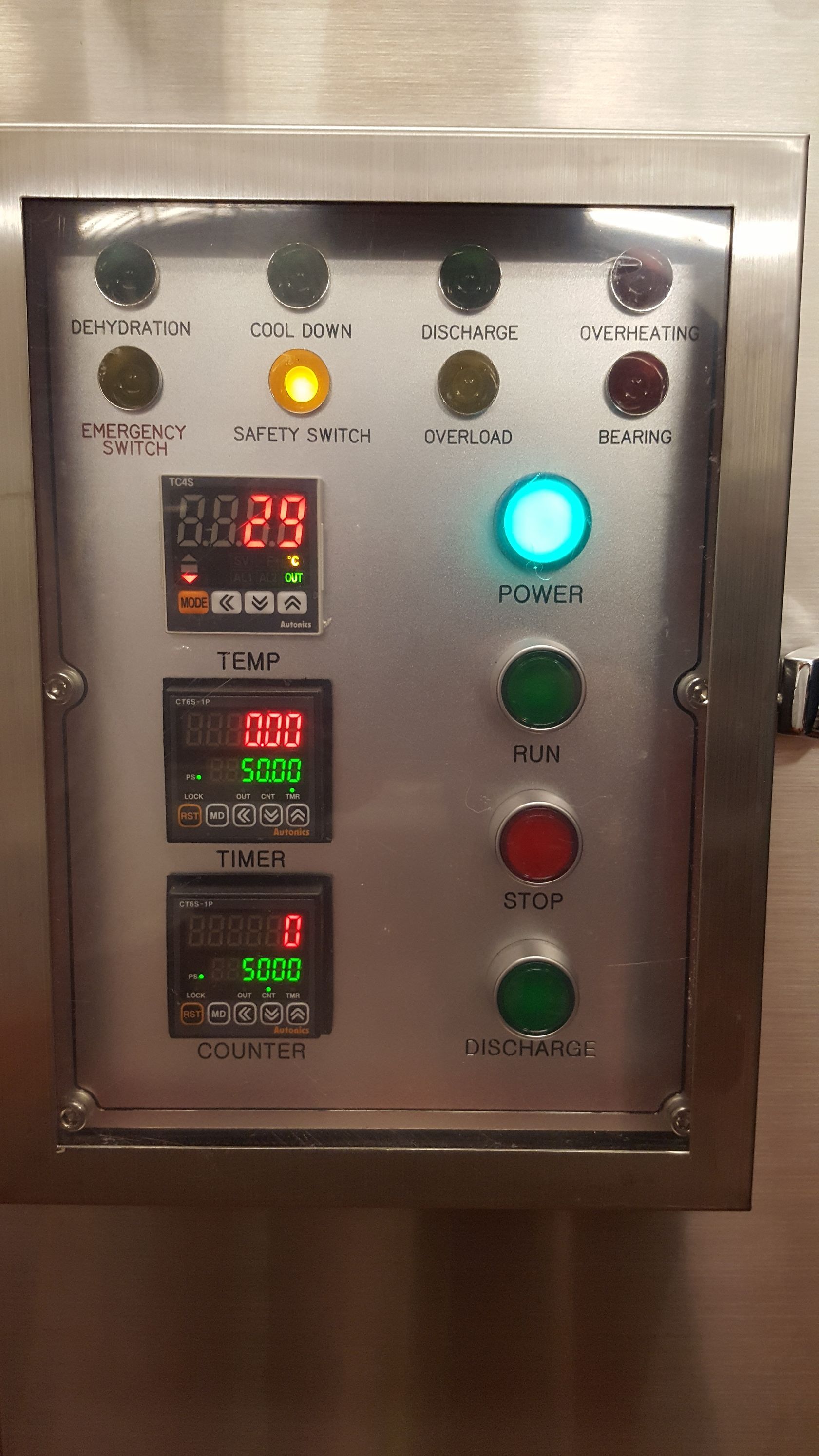 Panneau de commande en acier inoxydable avec affichage numérique, voyants lumineux et boutons. L'affichage indique la température ; le bouton marche/arrêt est éclairé.
