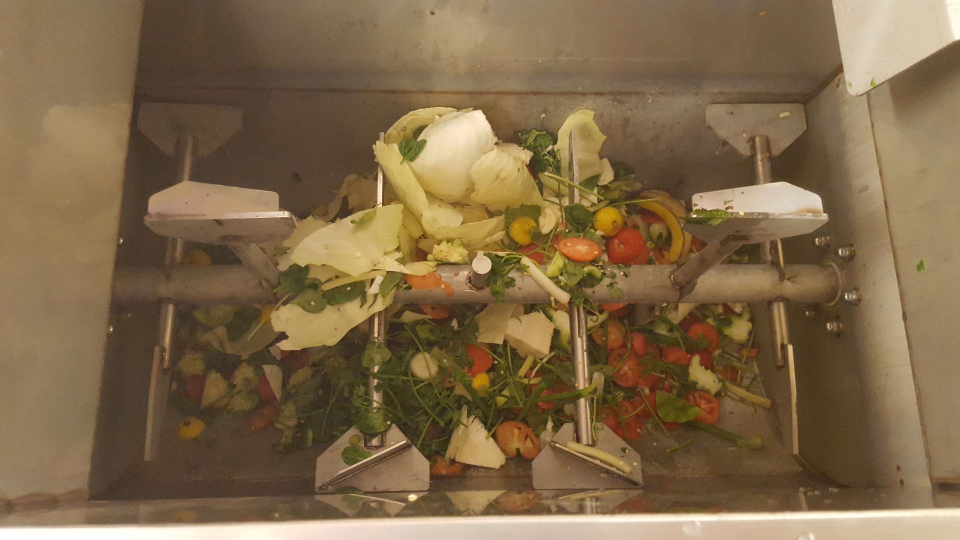 Composteur de déchets alimentaires avec épluchures de légumes mélangées.