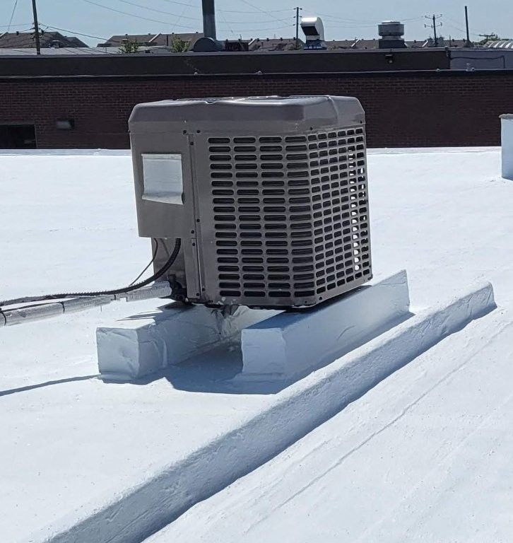 Unité de climatisation sur le toit blanc d'un immeuble commercial, par une journée ensoleillée.