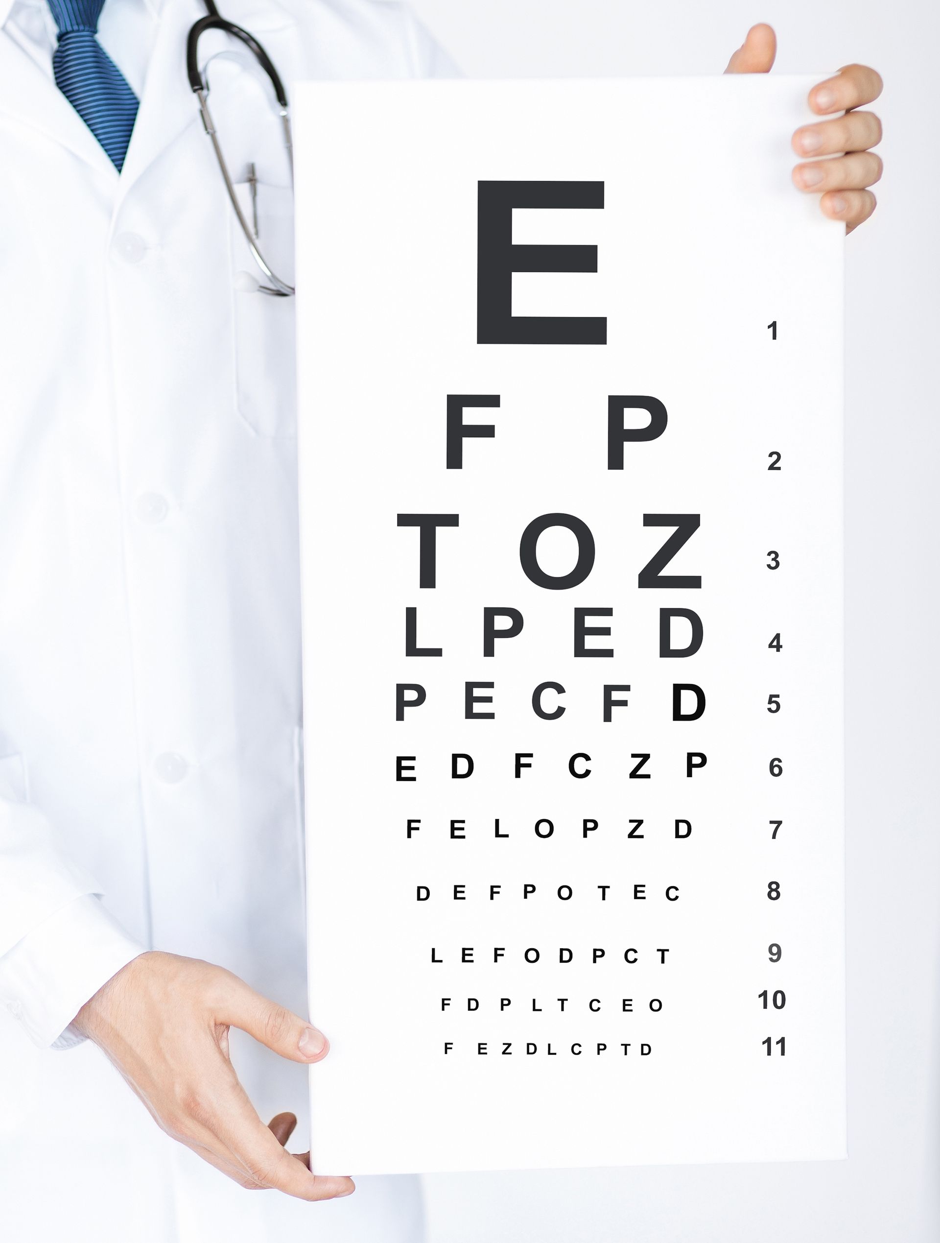 A doctor is holding up an eye chart with the letter e on it