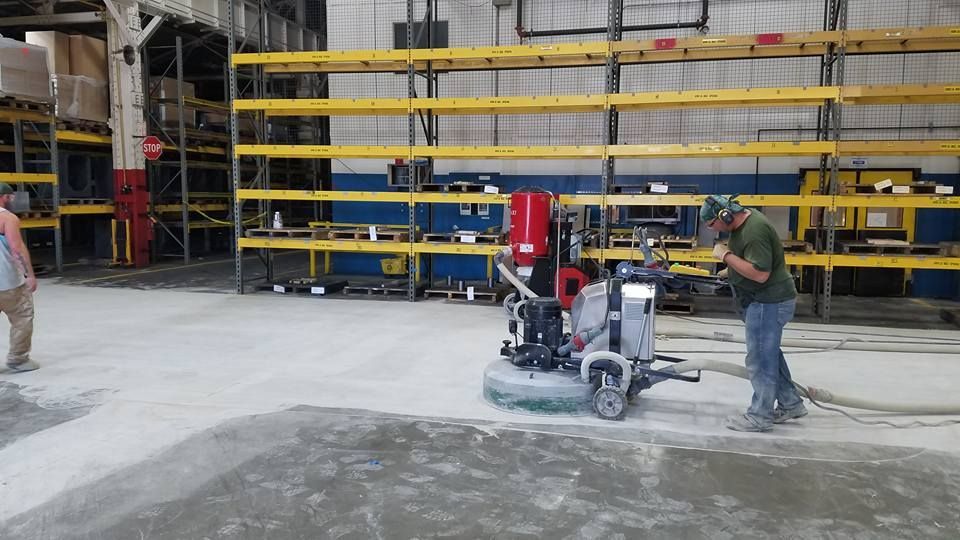 Floor grinder in an industrial warehouse, buffing concrete floor before polished concrete.