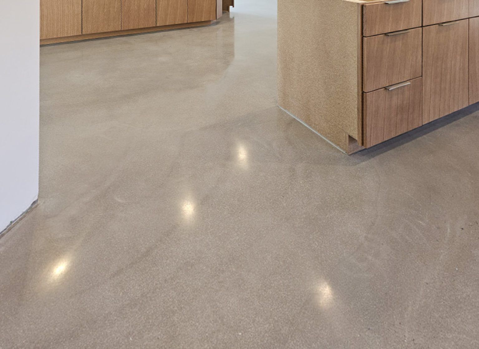 Polished concrete floor in a modern kitchen with wood cabinets