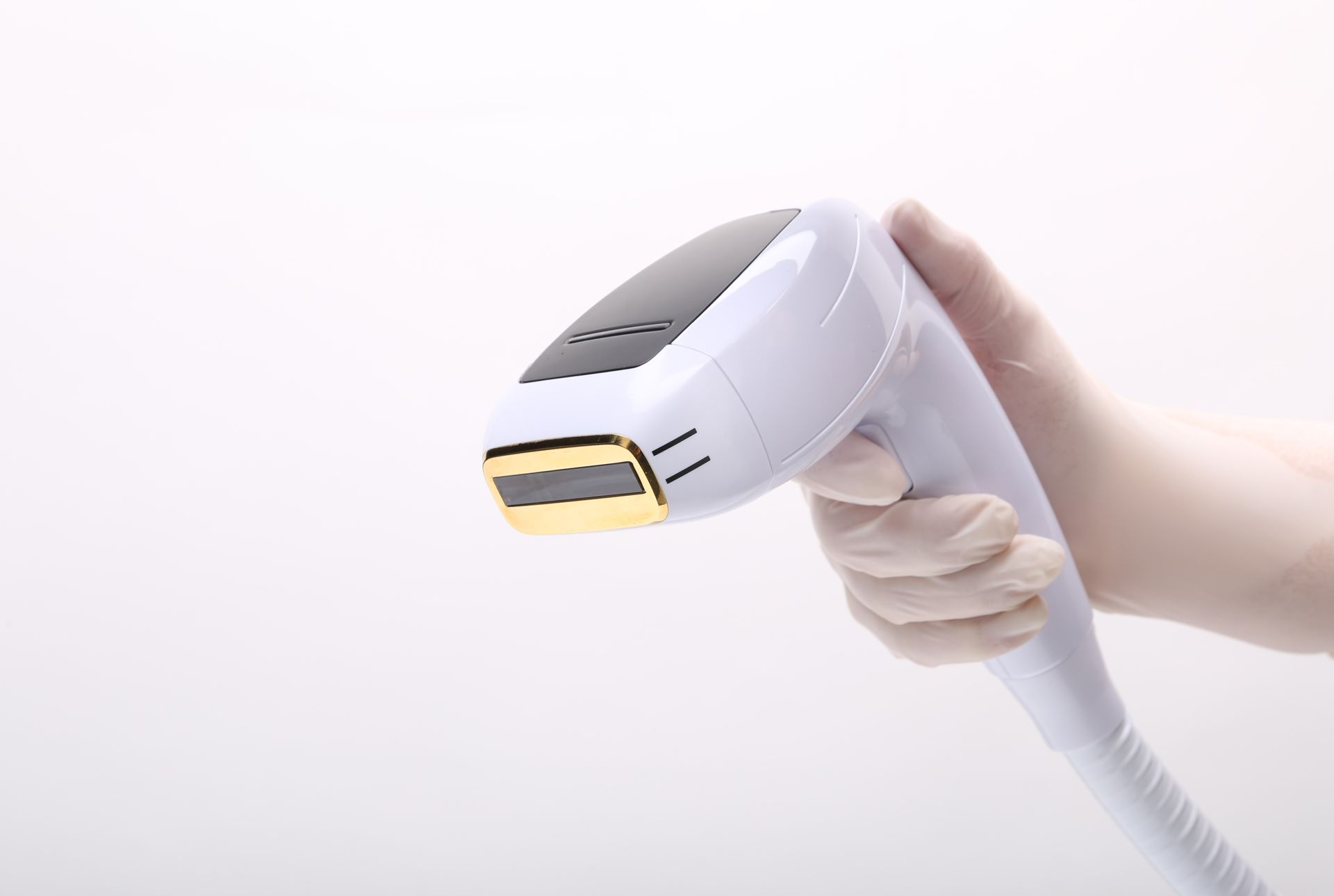 A person is holding a laser hair removal device in their hand.