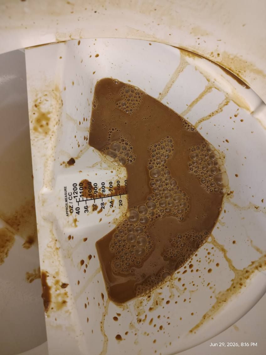 Brown stains and residue inside a white plastic container or appliance tray