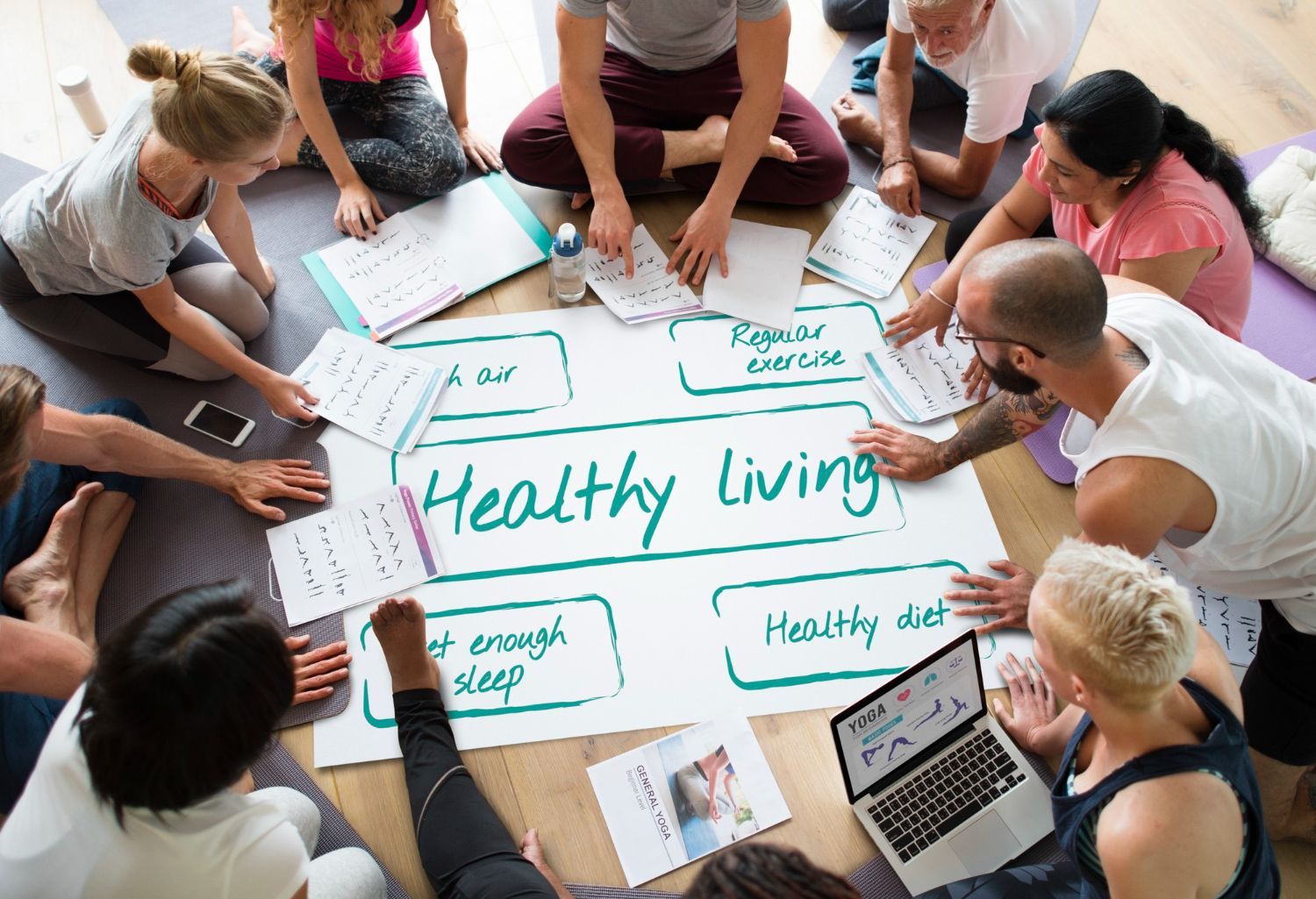 Group seated on floor around poster labeled