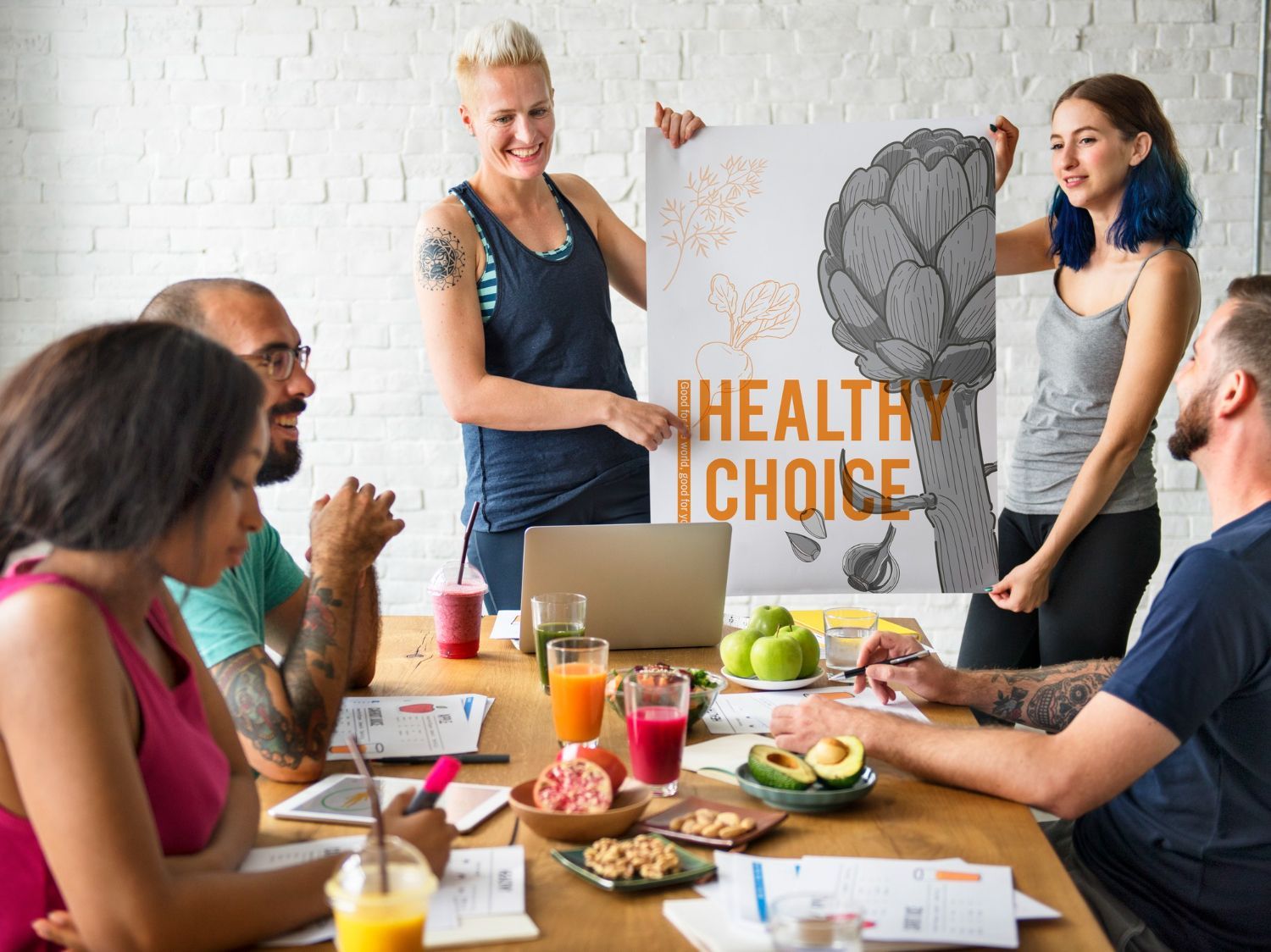 Group discussing healthy choices, woman pointing to poster with artichoke and