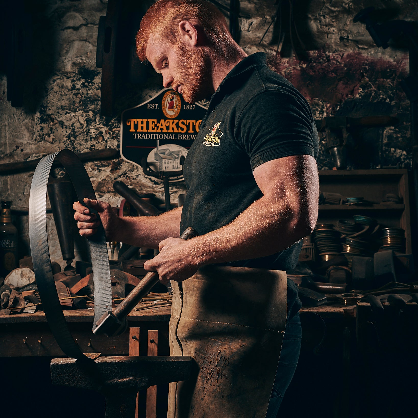 Blacksmith working in a dimly lit workshop, holding a curved metal piece. Red hair, focused expression.