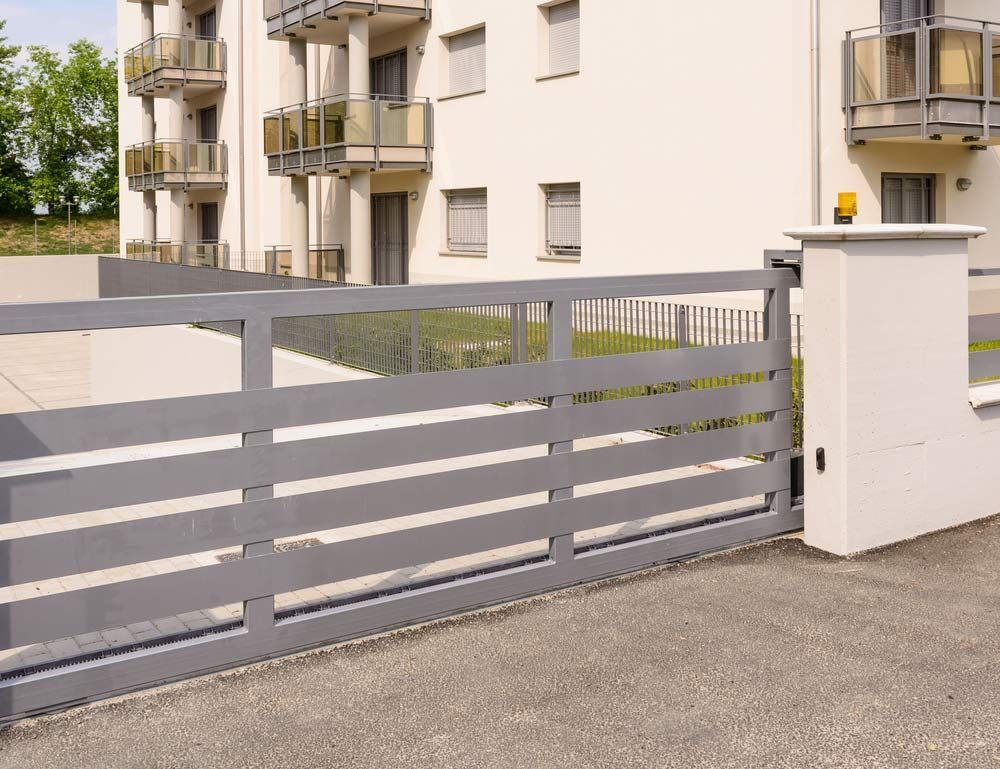 A Sliding Gate Is Open In Front Of A Building — Aliweld Fabrications In Caloundra West, QLD