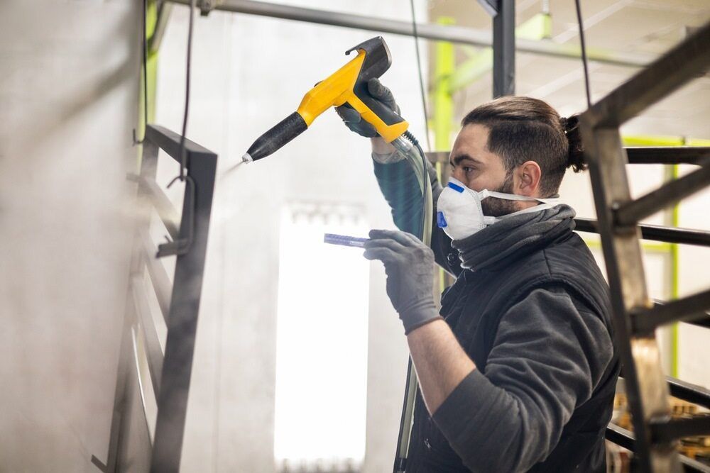 A Man Painting A Metal Fabric — Aliweld Fabrications In Caloundra West, QLD
