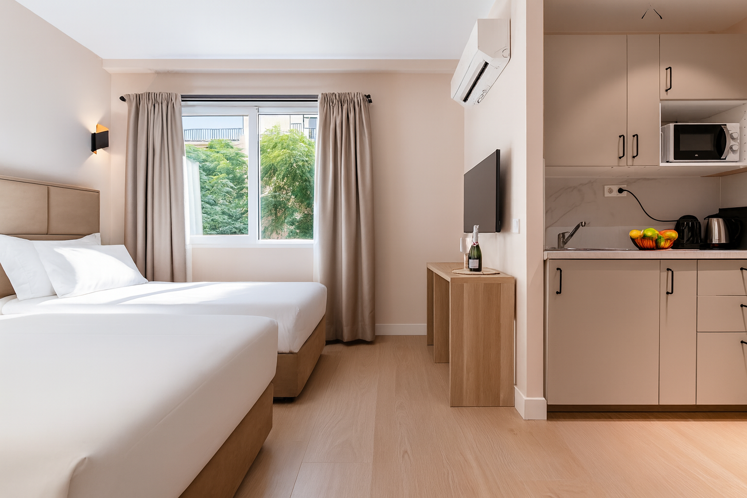 Apartamento tipo estudio con dos camas, cocina americana y vistas desde la ventana.