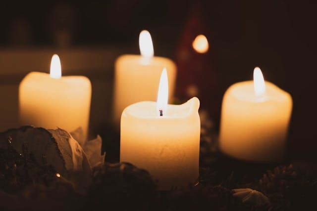 Four soft candlelights create a warm and reflective setting for cremation services Marrero, LA