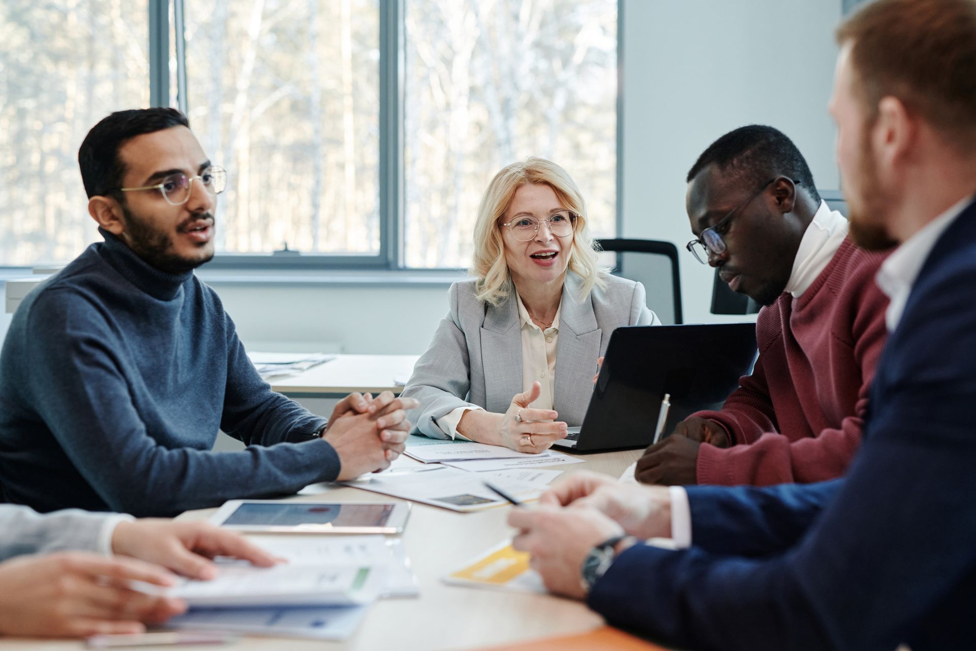 A group of people are sitting around a table having a meeting.