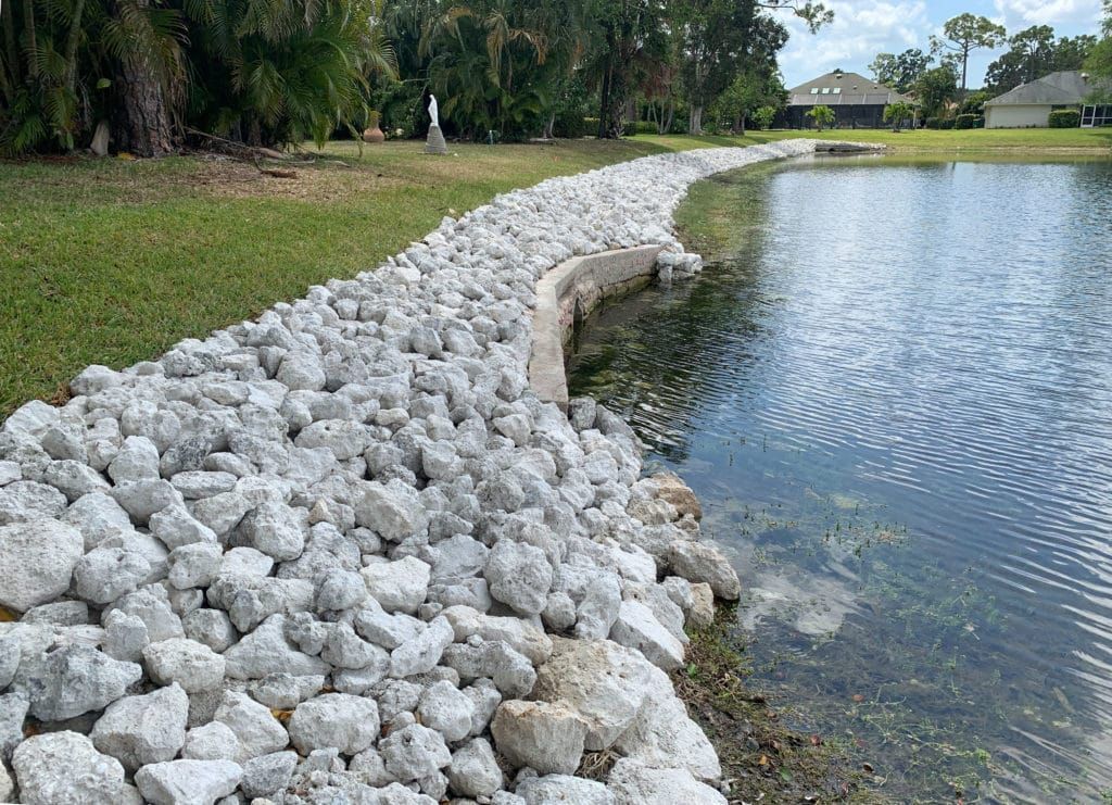 Shoreline of rocks next to water, protecting the grass from erosion.