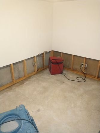 A corner of a room with exposed wooden wall studs.