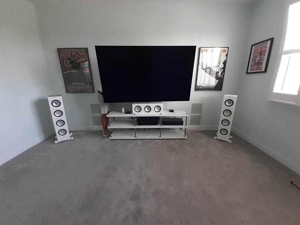 A living room with a flat screen tv and speakers.