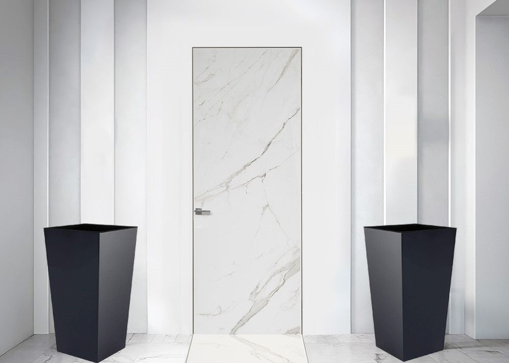 Una porta di marmo bianco è circondata da due fioriere nere.