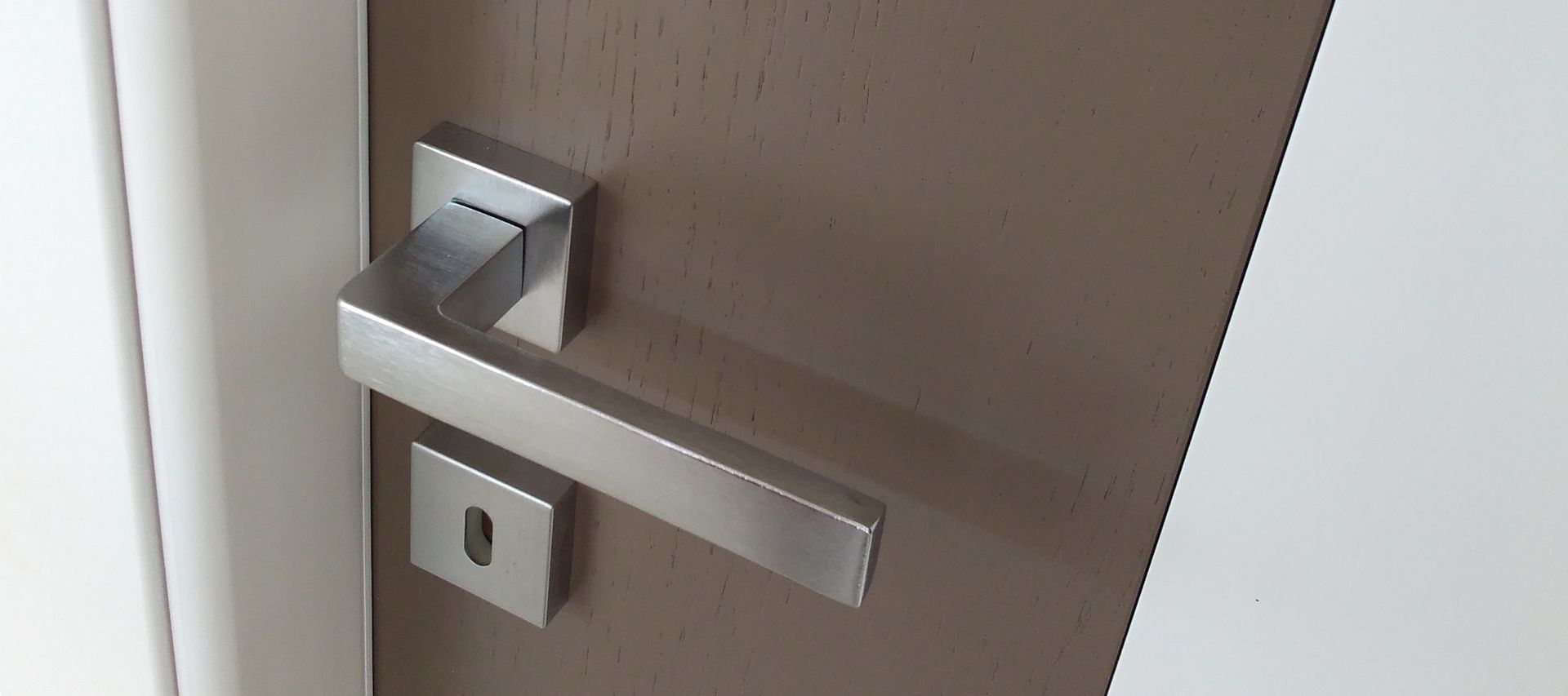 Un primo piano della maniglia di una porta marrone