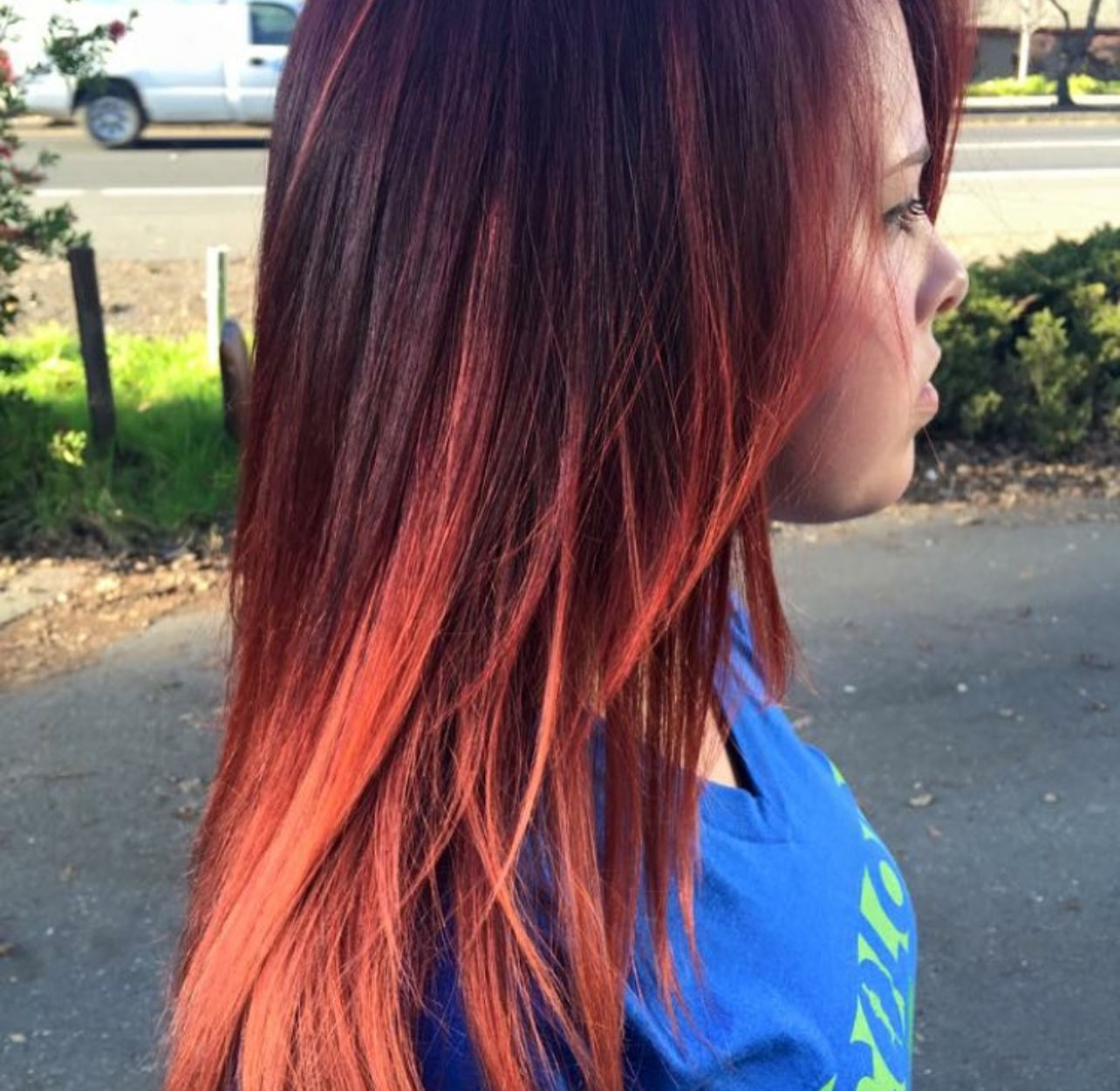 A woman with long red hair is wearing a blue shirt