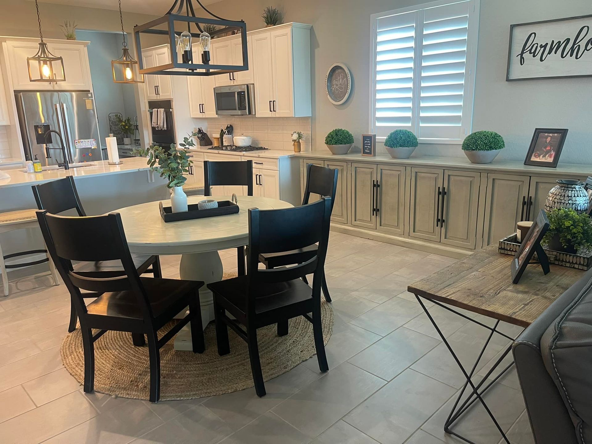 Dining room with round table, black chairs, and built-in cabinets with plants and decor.