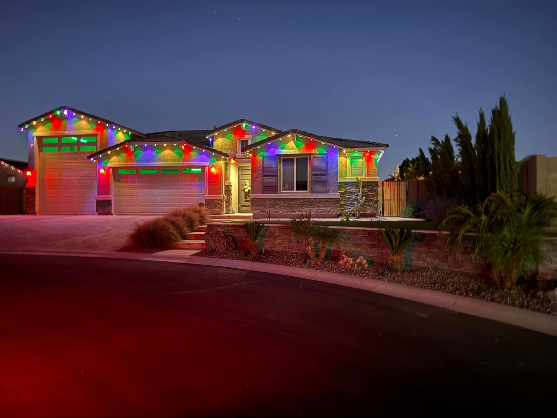 House with colorful Christmas lights at dusk.