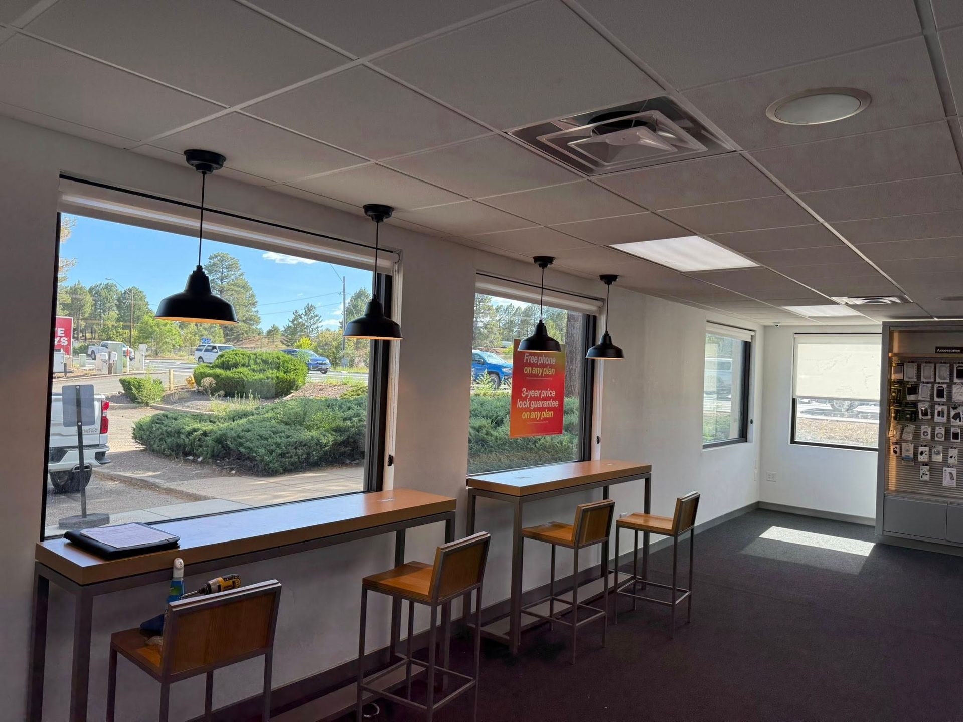 Interior with window counter seating and pendant lights. Street view visible outside.