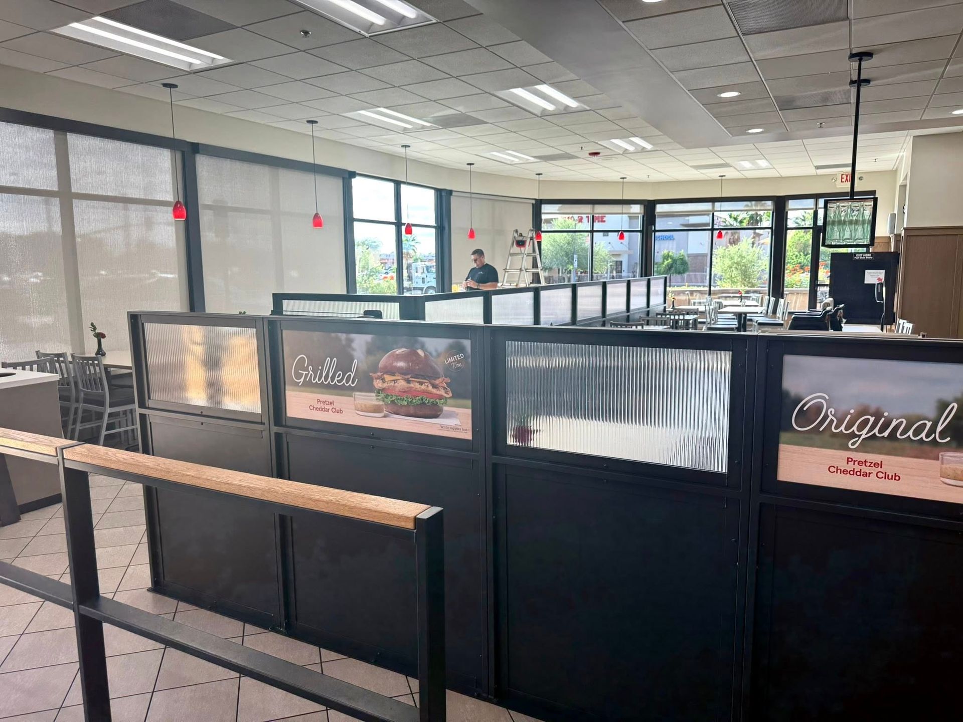 Interior view of a Chick-fil-A, showing ordering counters with partitions, and a person working behind the counter.