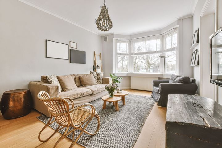 A living room with a couch , chairs , and a television.