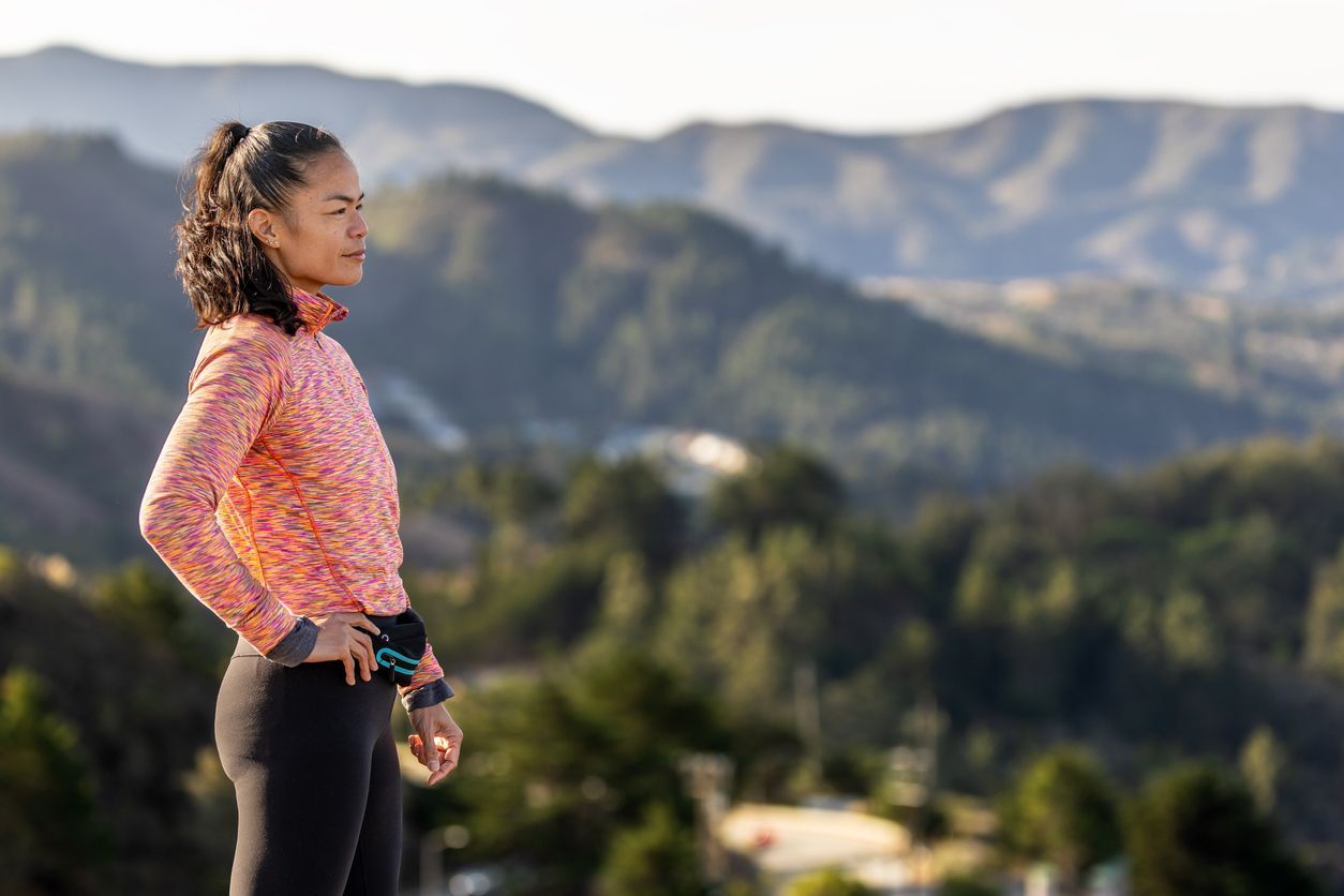 Person overlooking mountains and trees, symbolizing reflection, healing, and finding meaning.