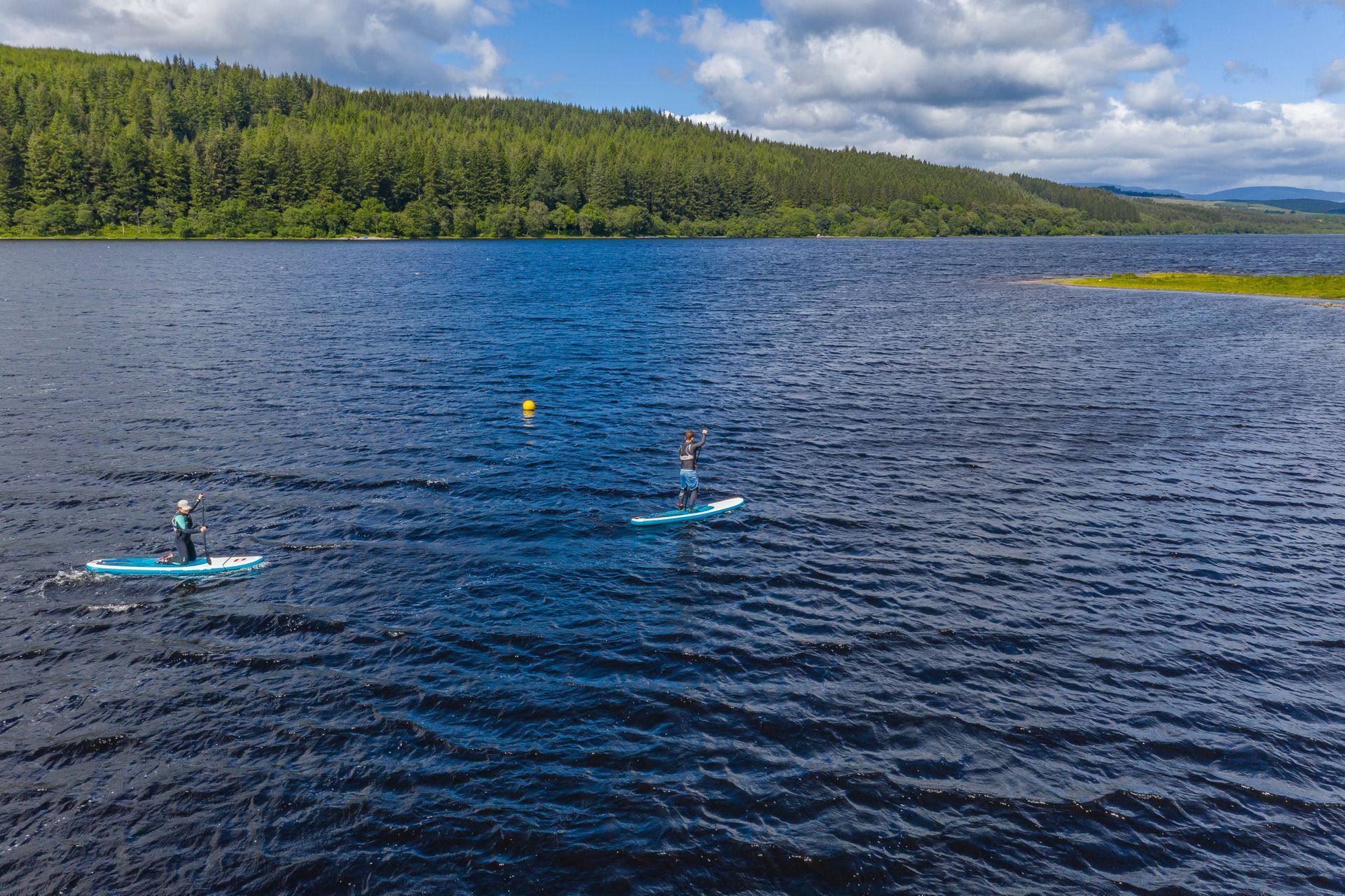 A group of people are riding paddle boards on a lake.