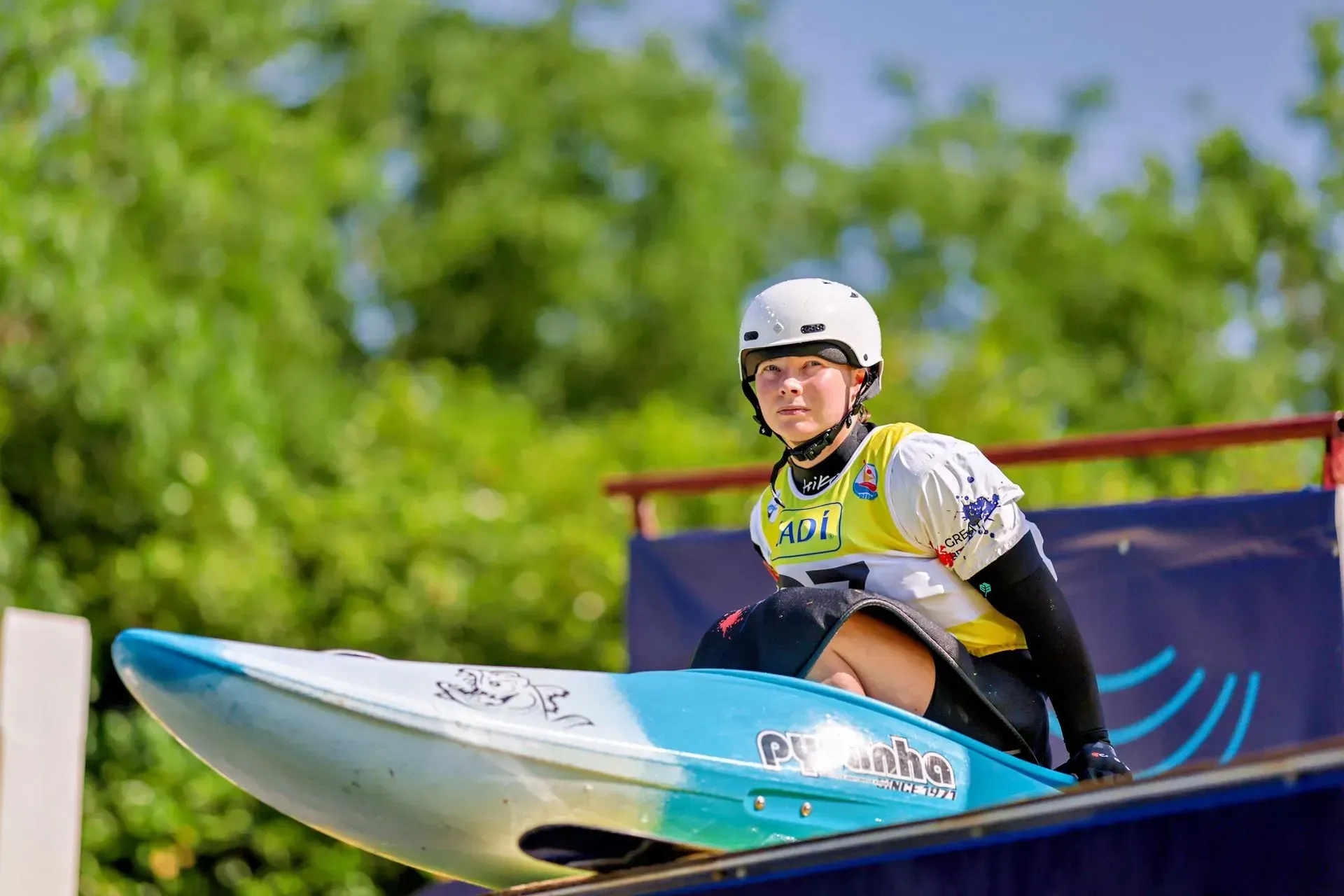 A person is sitting in a kayak on top of a ramp.